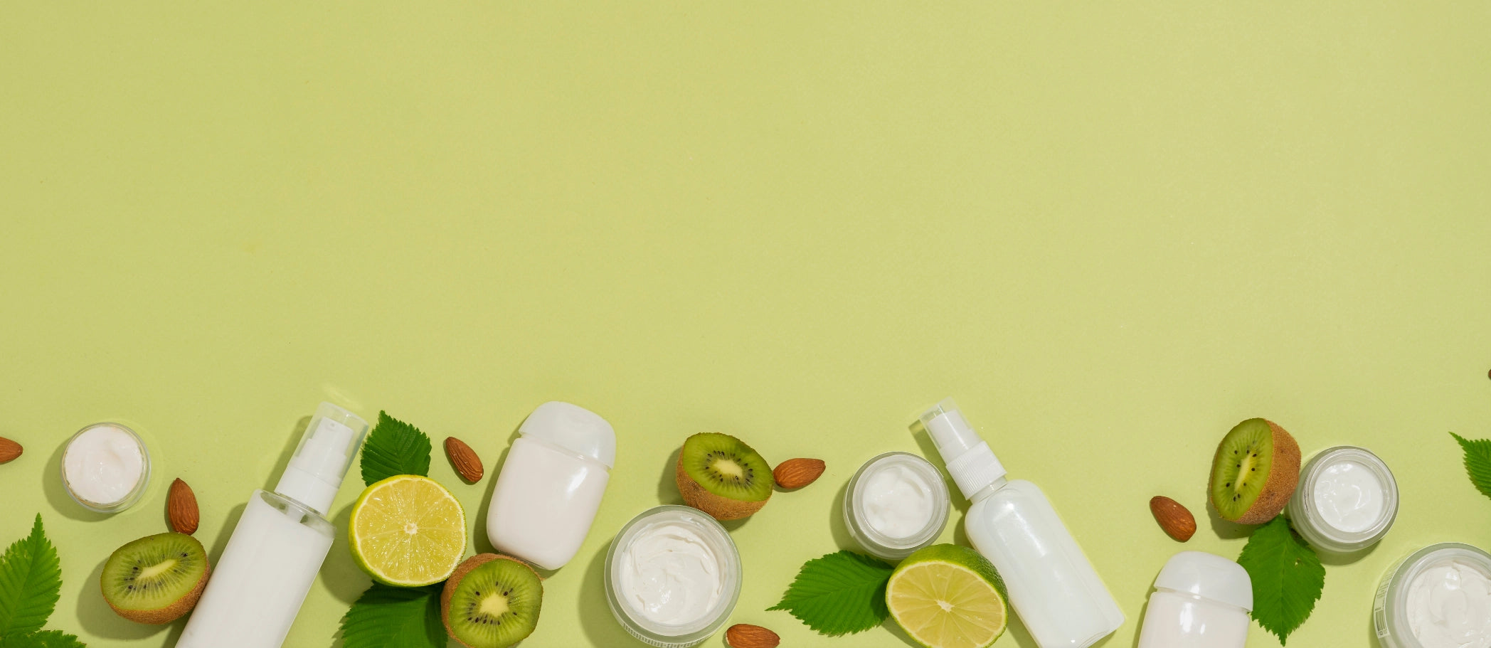 Kosmetikprodukte mit natürlichen Inhaltsstoffen wie Kiwi, Limette, Mandeln und Blätter – frisches Banner für Purida K-Beauty