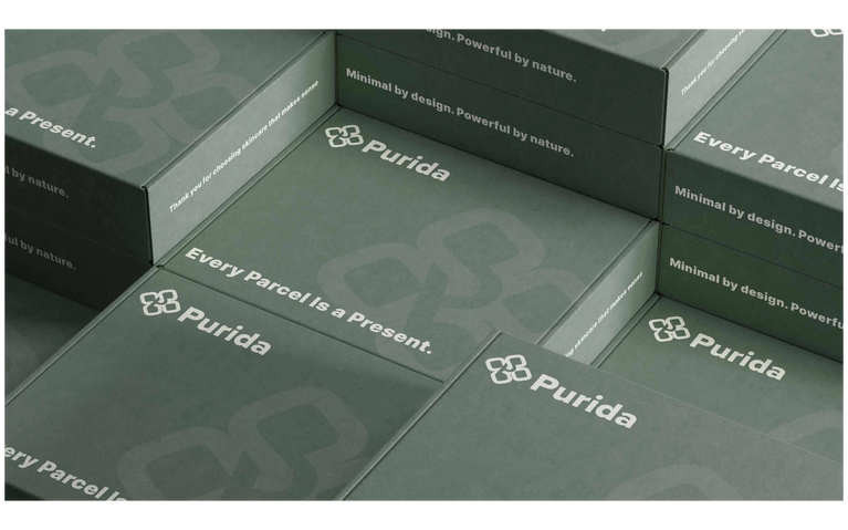 Purida Versandboxen in elegantem Grün mit Logo und Claim – Every parcel is a present. Premium K-Beauty Service aus Hamburg.