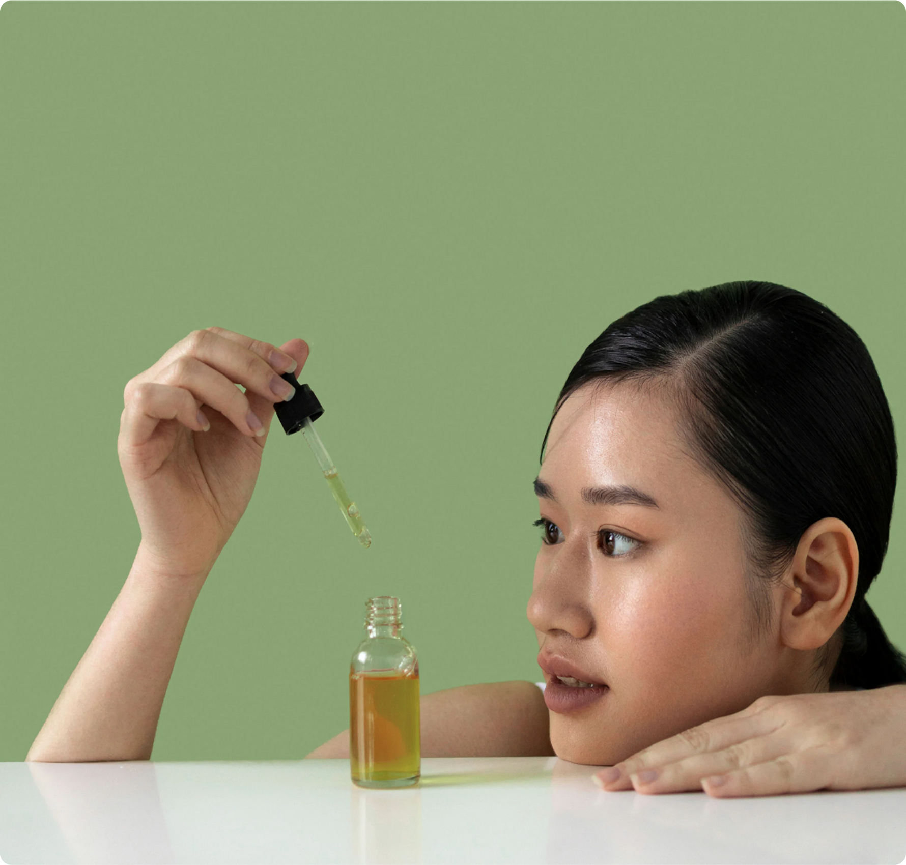 Frau trägt koreanisches Serum mit Dropper auf – moderne Hautpflegeroutine